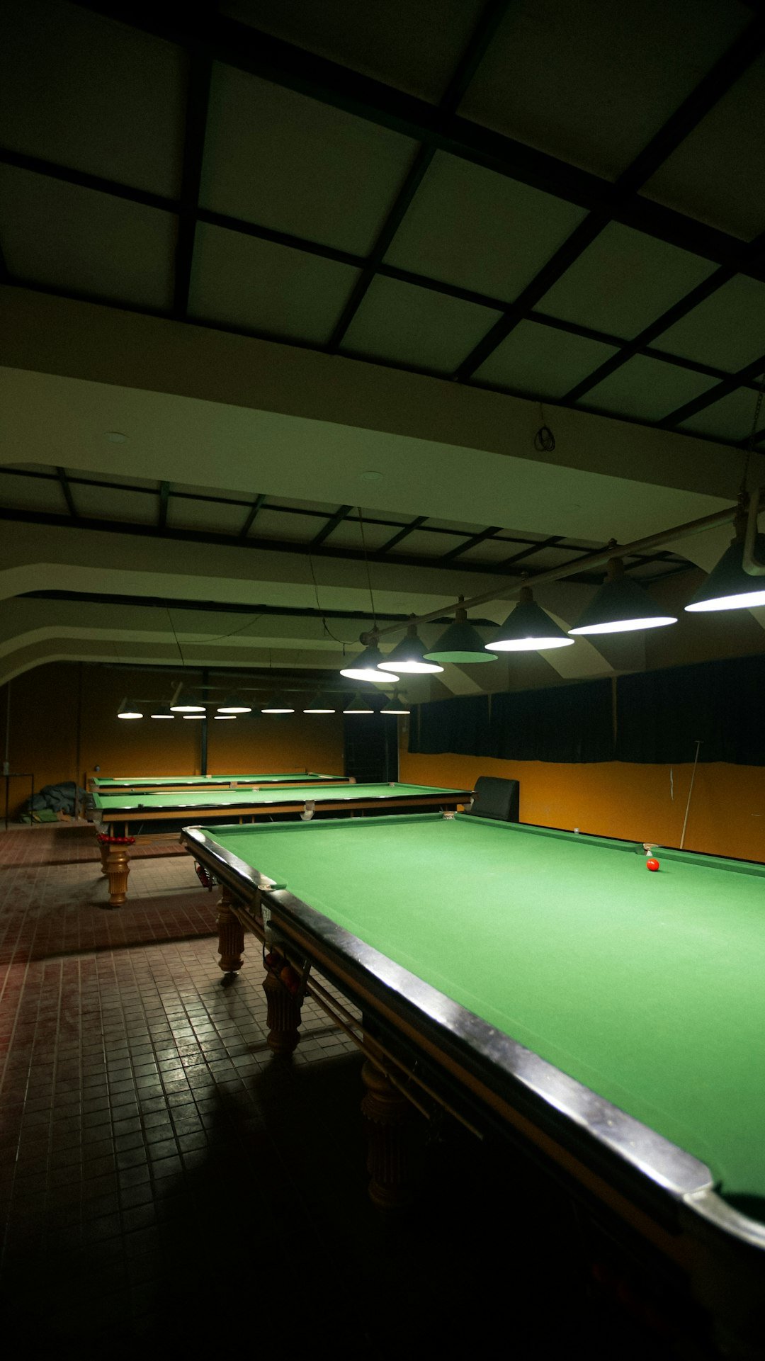 a-green-pool-table-in-a-dark-room-uiynpcgkwq