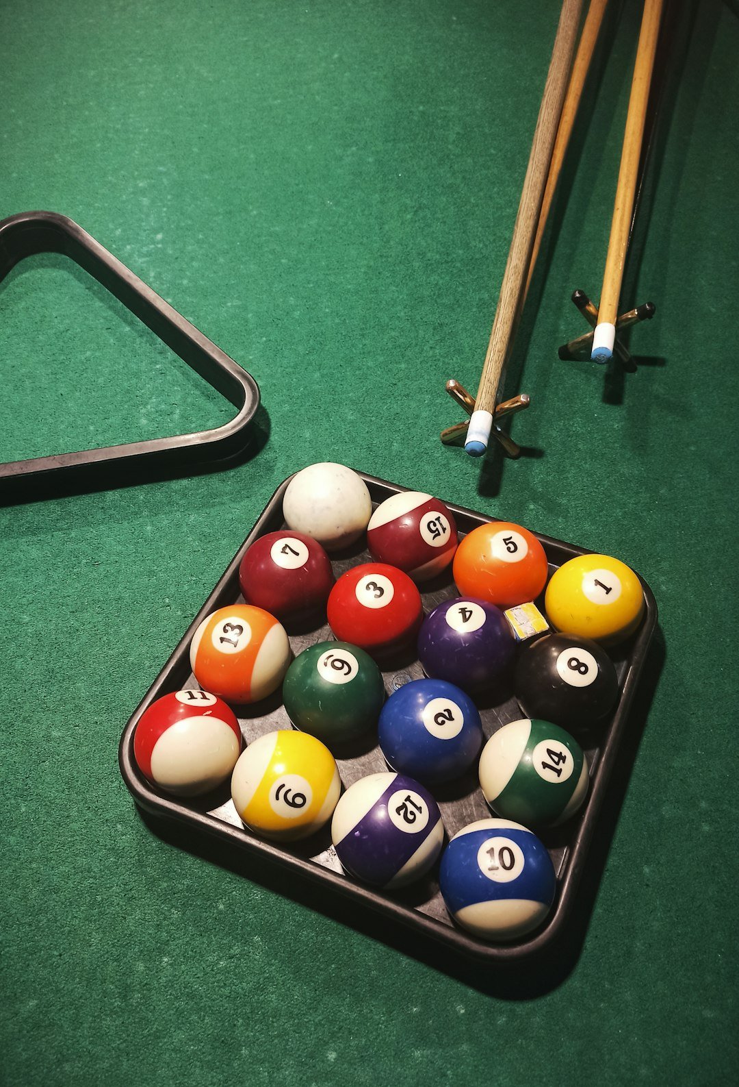 a-pool-table-with-a-rack-of-pool-balls-and-cues-781zhutz2sq