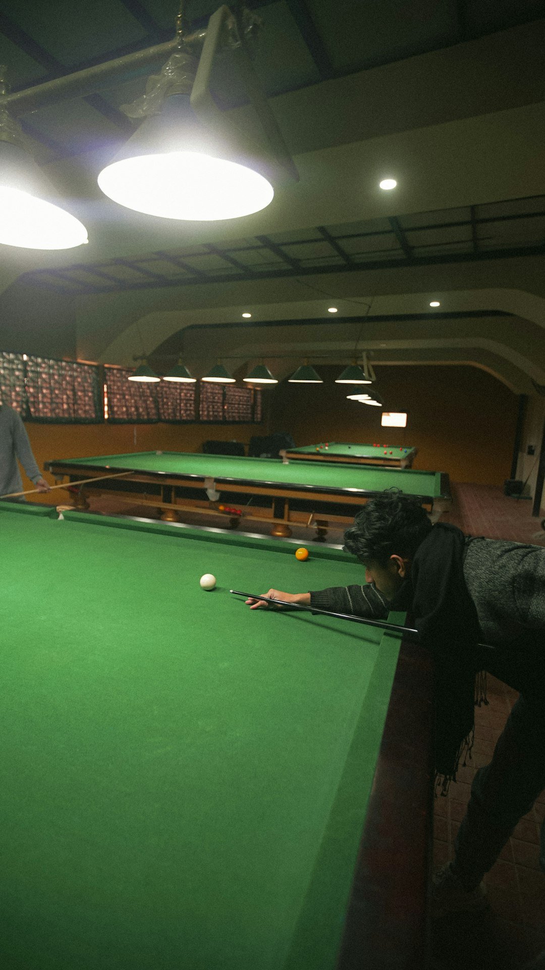two-people-playing-pool-in-a-large-room-mkj7psy0cxs